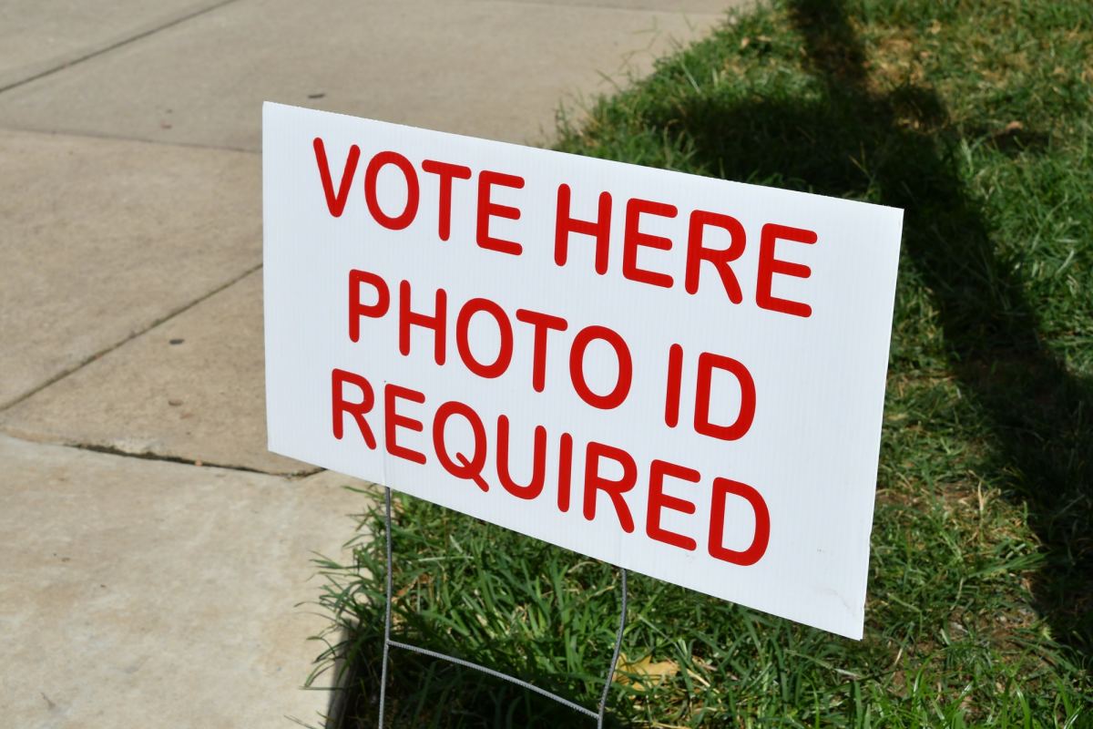 Sign showing where to vote on election day at the polling place. Vote Here, Photo ID Required