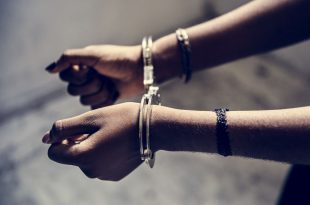 Closeup of arrested hands with handcuffs