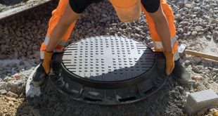 Installing cast iron sewer hatch on a concrete base of installation of water main sewer well in the