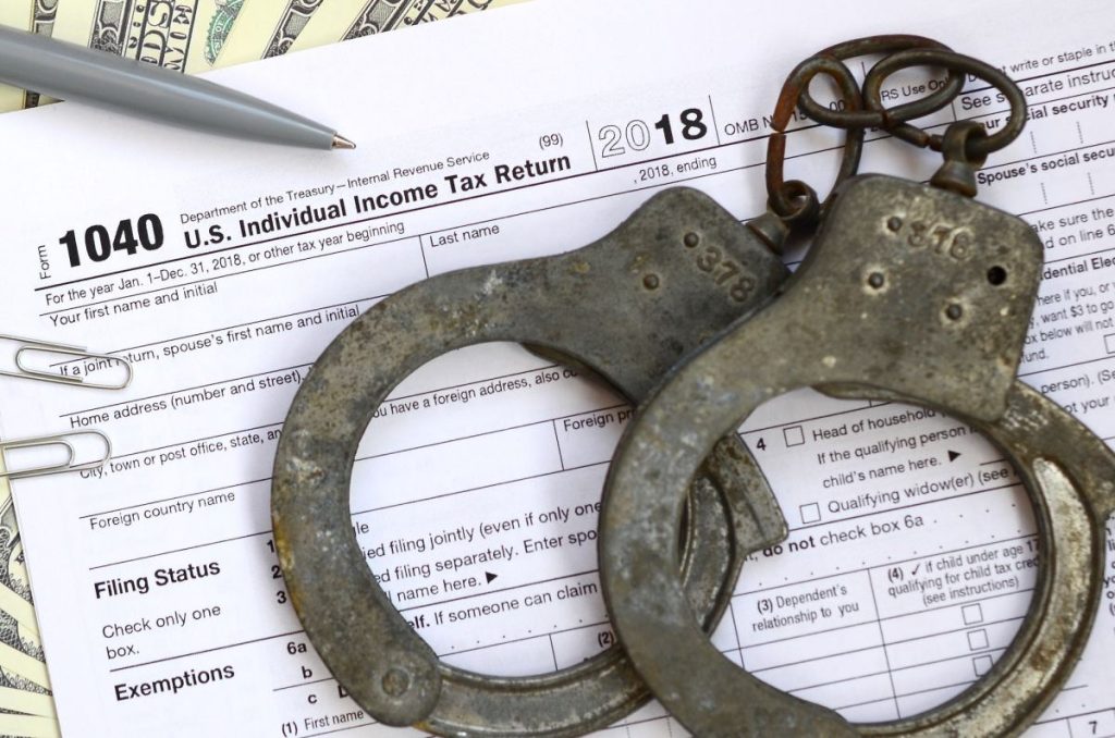 Police handcuffs lie on the tax form 1040