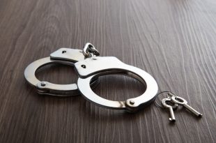 Police metal handcuffs on dark wooden background