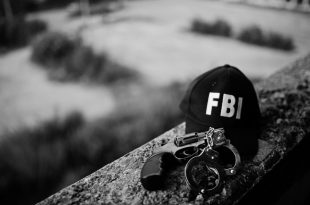 FBI cap with revolver and handcuff.