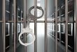 Handcuffs on jail cell closed metal bar door. Prison building corridor background, 3d render