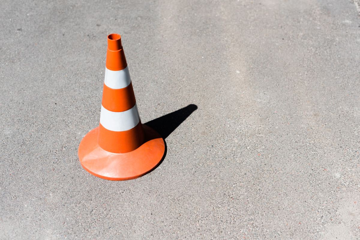 Orange and white traffic cone on asphalt road