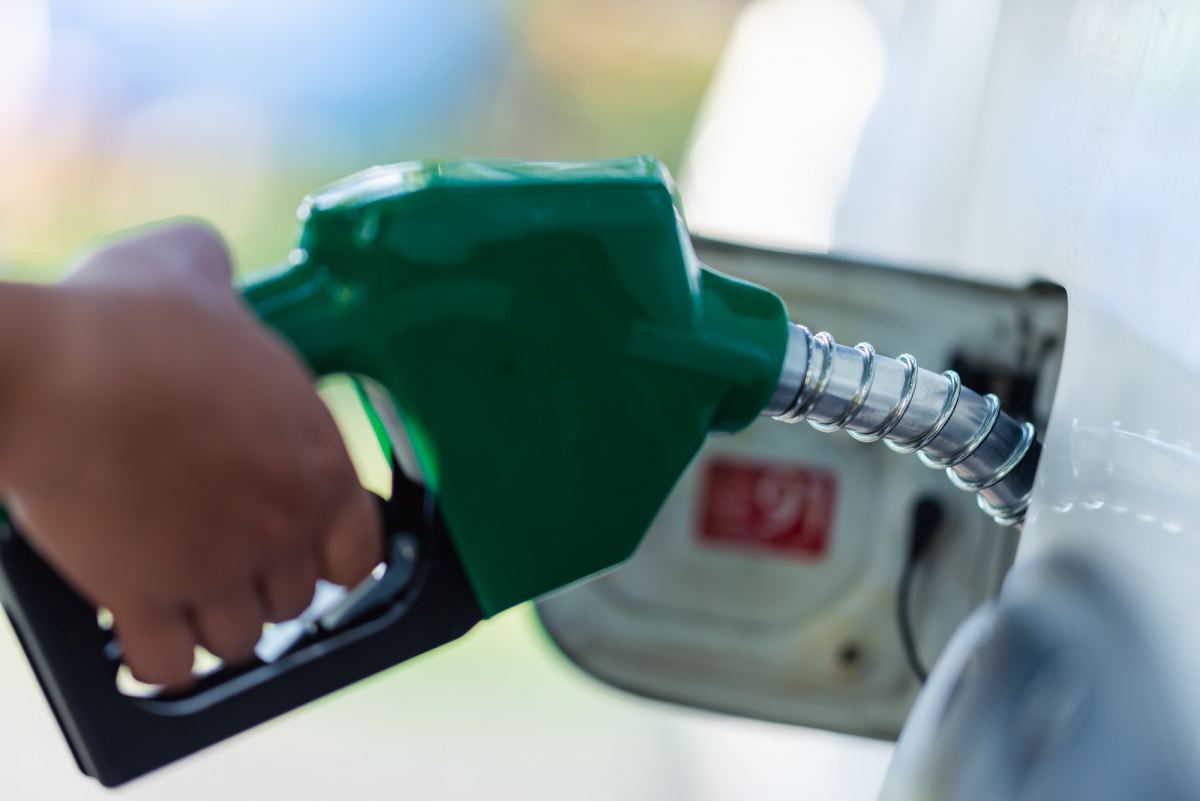 handle pumping gasoline fuel nozzle to refuel. vehicle fueling facility at petrol station