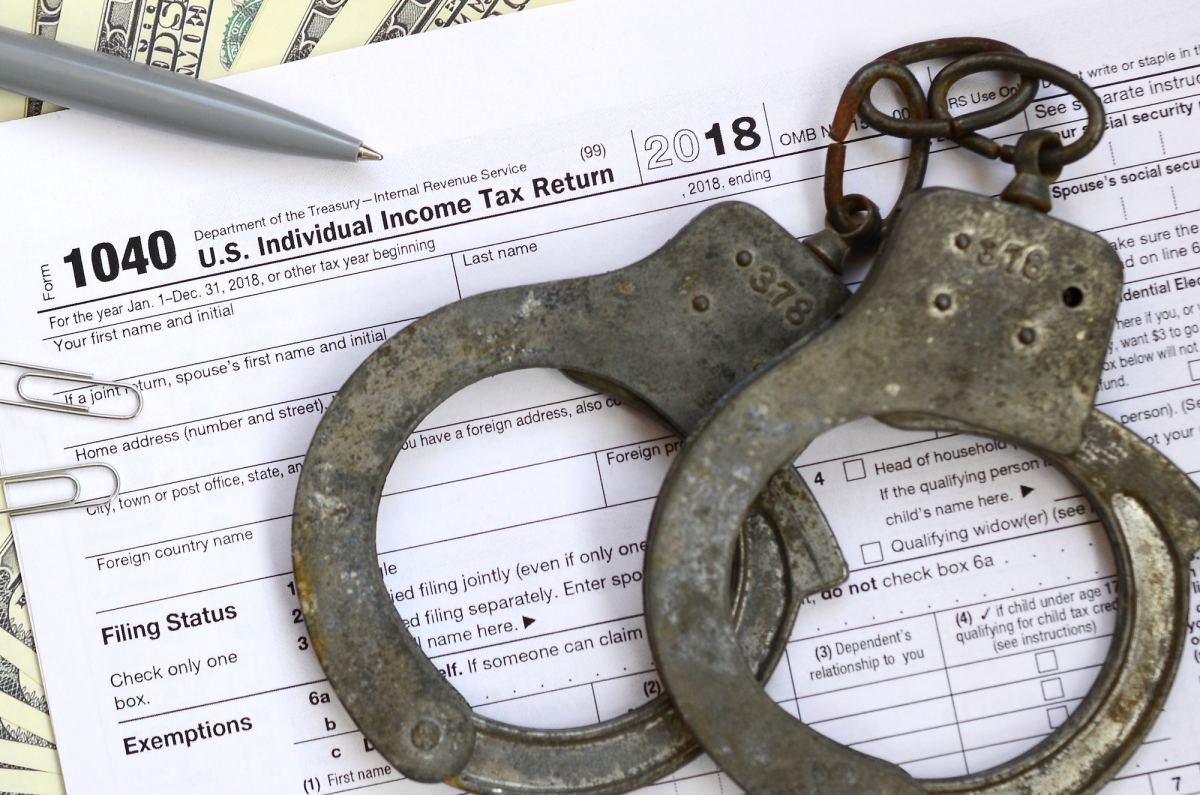 police handcuffs lie on the tax form 1040