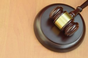 justice mallet on wooden desk in a courtroom during a judicial trial