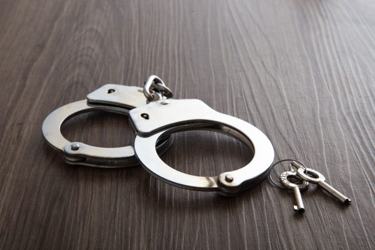 police metal handcuffs on dark wooden background