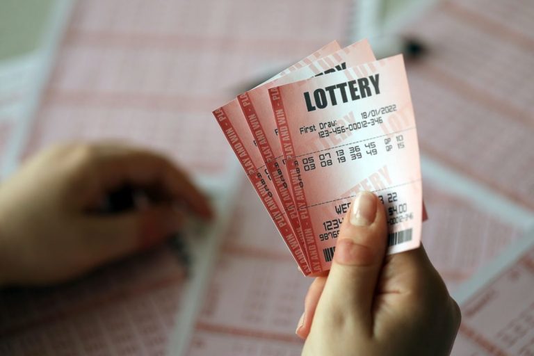 filling out a lottery ticket. a young woman holds the lottery ticket with complete row of numbers