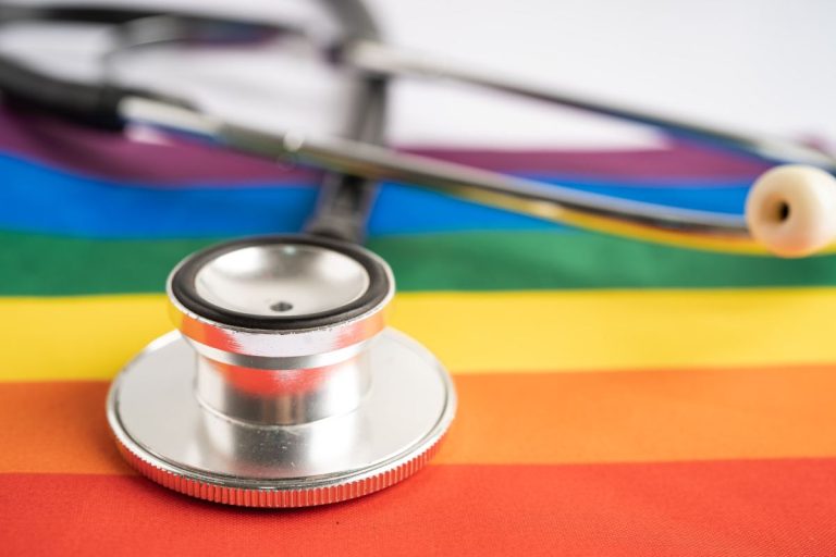 black stethoscope on rainbow flag background, symbol of lgbt pride month celebrate annual in june