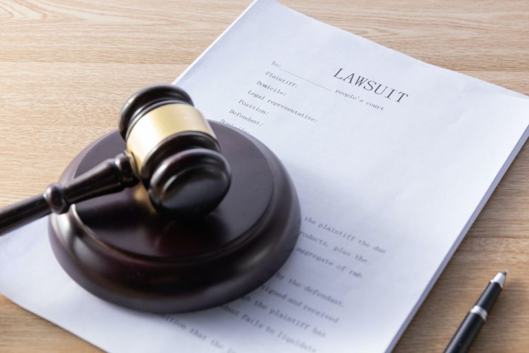 high angle shot of a gavel and lawsuit papers on a wooden surface