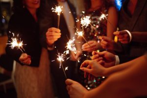 sparkling sparklers in hands. playing firework to celebrate winter holidays with friends at party