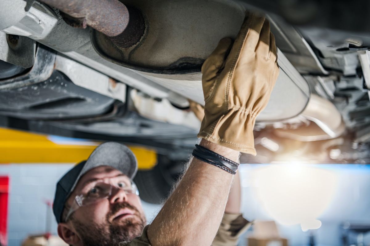 professional mechanic performing car catalytic converter check