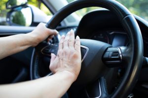 close,up,view,of,car,steering,wheel,and,hand,pressing